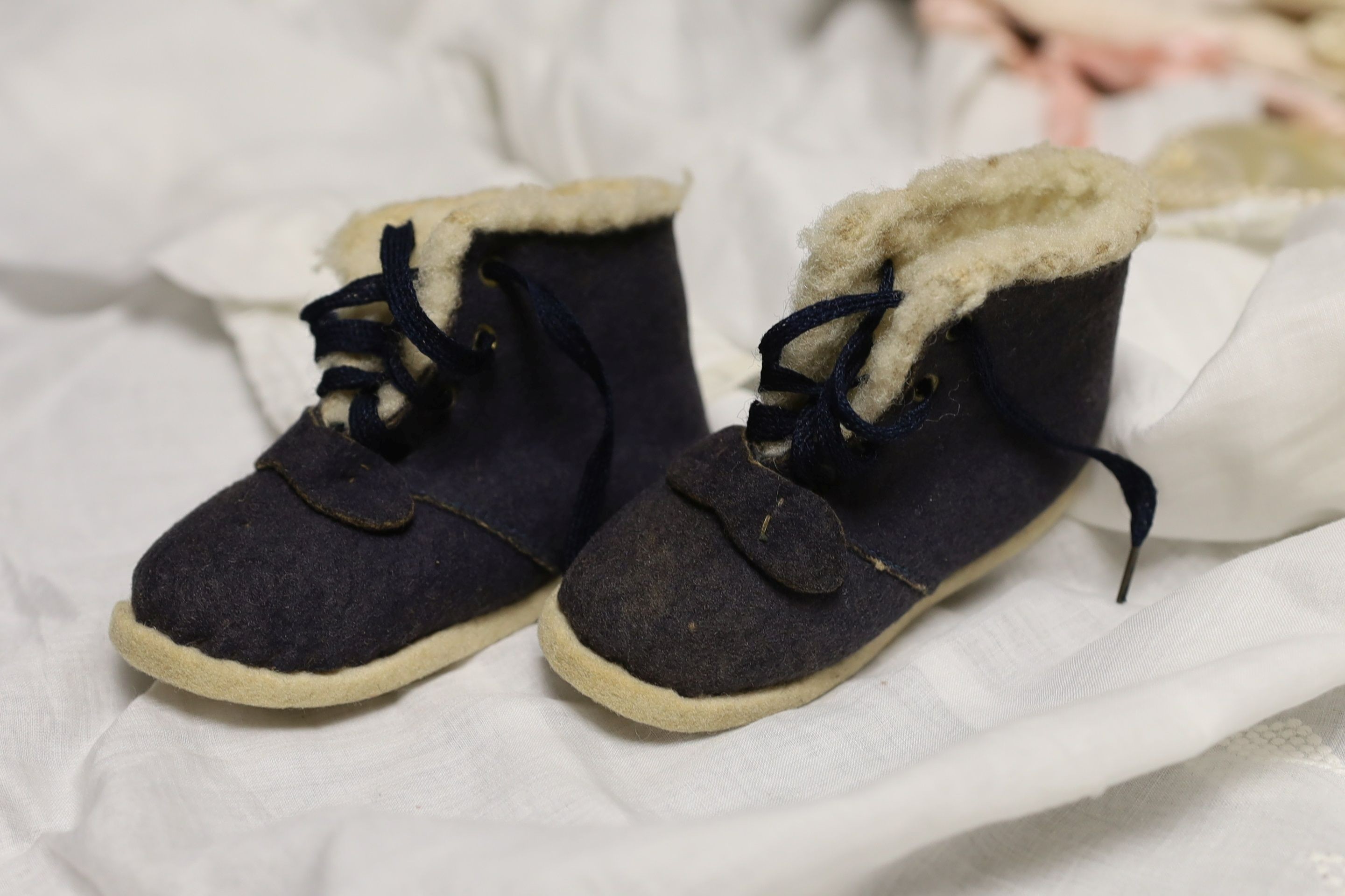 A pair of felt fur-lined child's boots and a whitework communion dress, a handkerchief sachet and two satin embroidered sachets